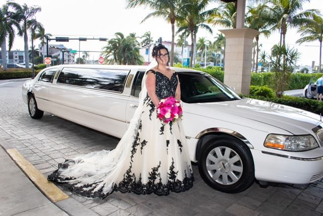 Model wearing a white gown near the car
