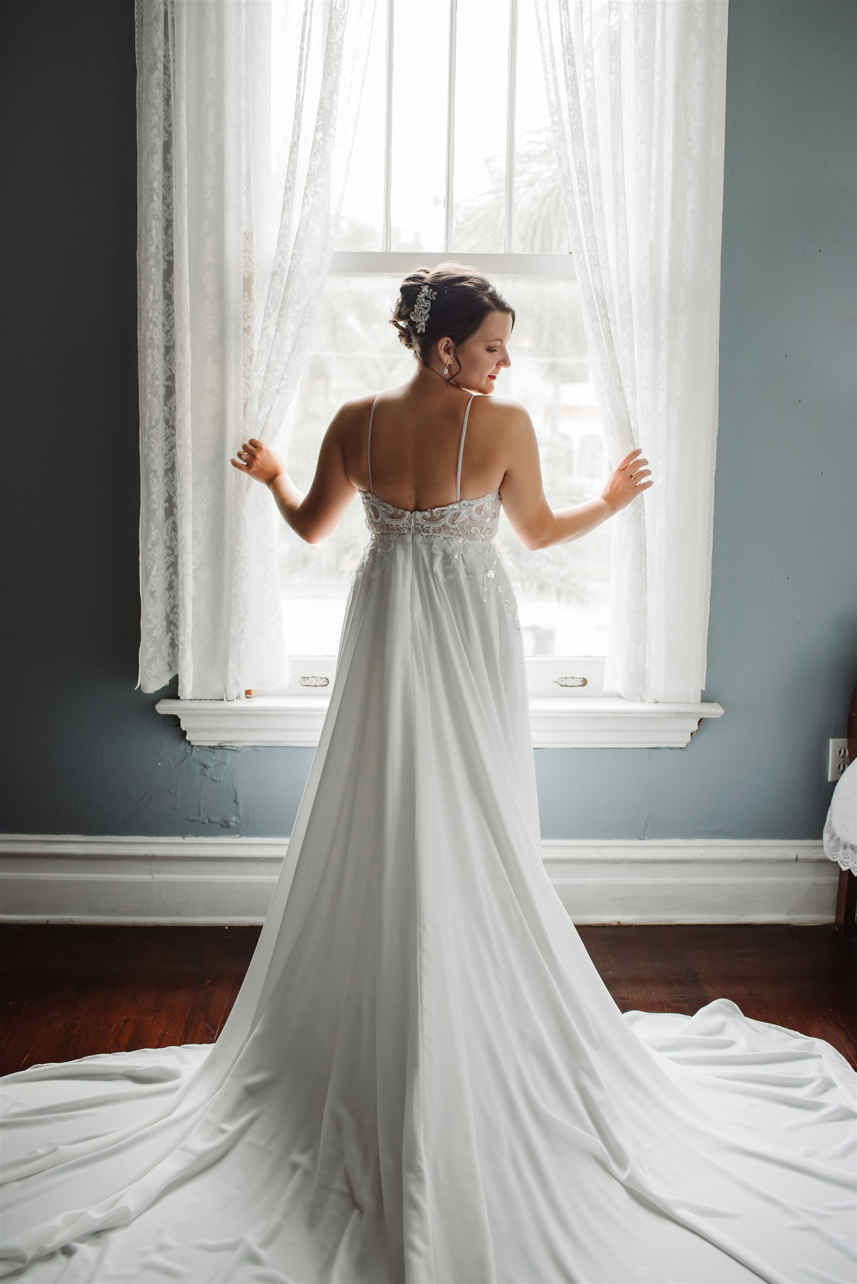 Model wearing a white gown at the window